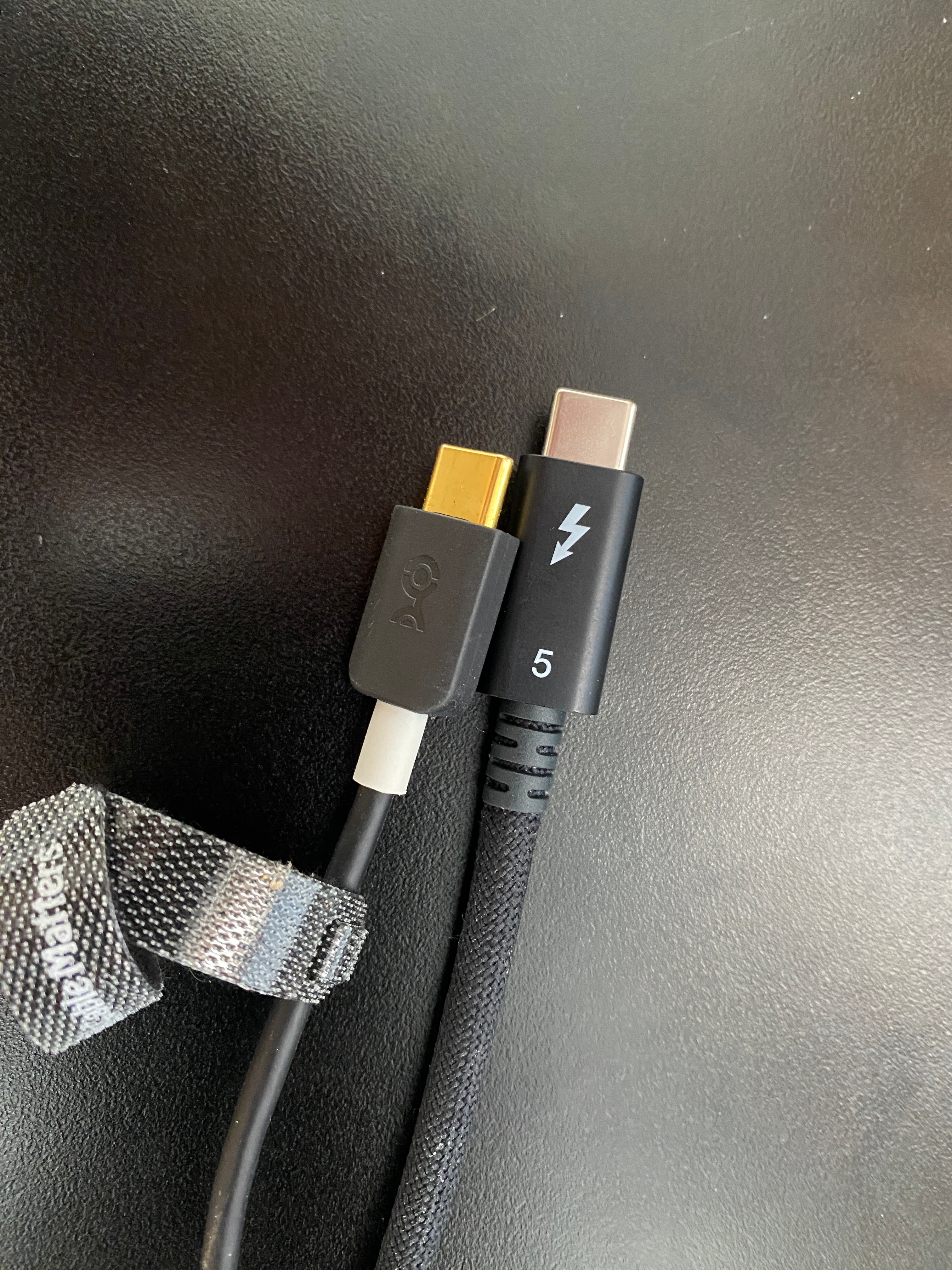 Two USB-C connectors side by side, one stamped with the Thunderbolt symbol and one unmarked